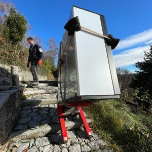 Transport d'une chaudière sur un escalier extérieur en pierre